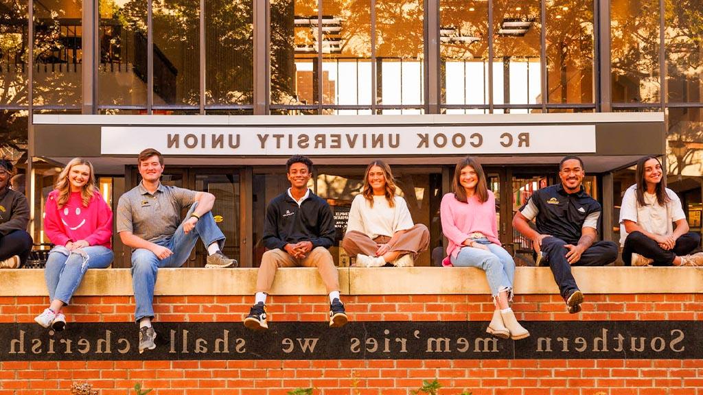 students sitting on wall